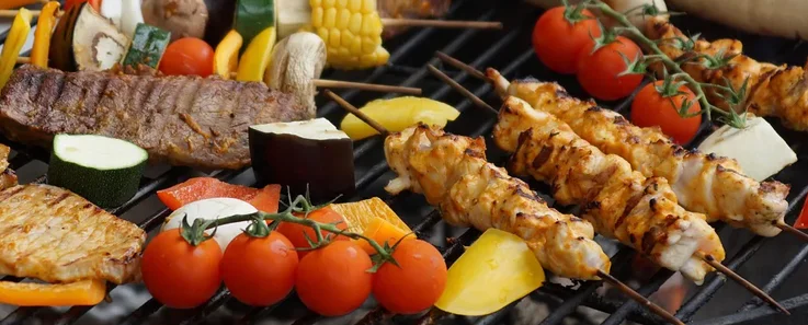 Fleisch und Gemüse liegen auf einem Grill